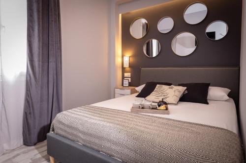 a bedroom with a large bed with mirrors on the wall at Ionian City in Corfu Town