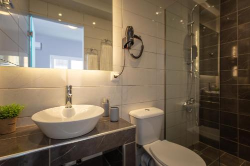 a bathroom with a sink and a toilet and a shower at Ionian City in Corfu Town