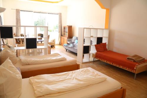a living room with three beds and a couch at Pension Isartal in Geretsried