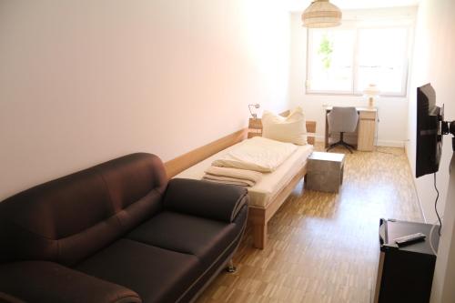 a living room with a couch and a table at Pension Isartal in Geretsried