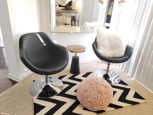 a room with two chairs and a rug at Penthouse Dreams in Irvine