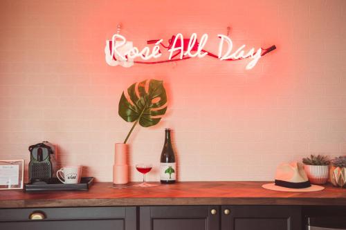 a neon sign that says dog all day on a wall at The June Motel, Prince Edward County in Picton