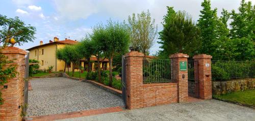 a brick fence with a gate in front of a house at Torrebianca Tuscany in Rignano sullʼArno