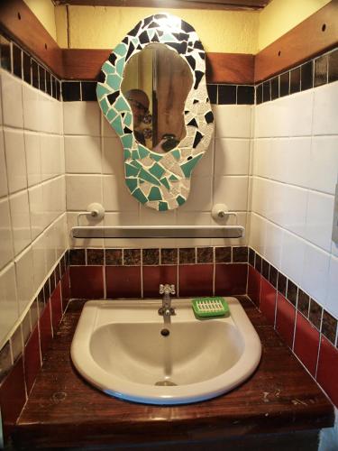 a bathroom with a sink and a mirror on the wall at Pousada Casa Milà in Ubatuba