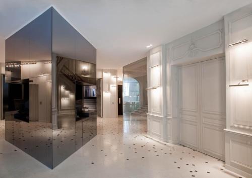 einen Flur mit großem Spiegel in einem Gebäude in der Unterkunft La Maison Champs Elysées in Paris