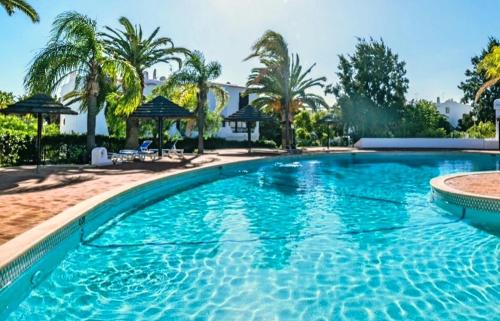 una grande piscina blu con palme di CASA ELISA SAO RAFAEL ad Albufeira