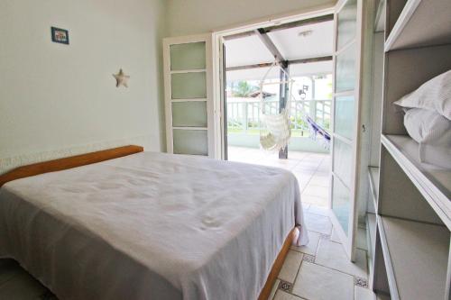 a bedroom with a bed and a sliding glass door at CASA TEMPORADA TUCO E TUCA in Ubatuba