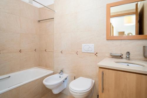 a bathroom with a toilet and a sink and a bath tub at AL Cabanas de Tavira in Cabanas de Tavira