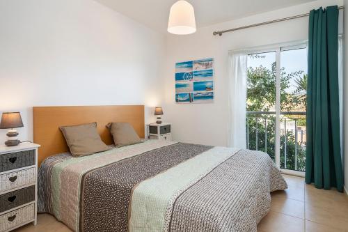 a bedroom with a bed and a large window at AL Cabanas de Tavira in Cabanas de Tavira