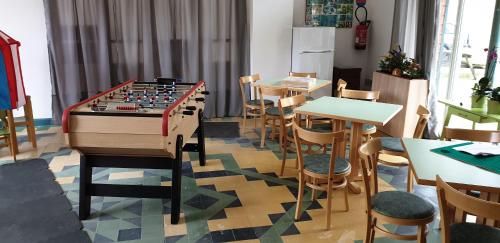 una habitación con un tablero de ajedrez gigante, mesas y sillas en Résidence les Mélèzes de Prades Ariège en Prades