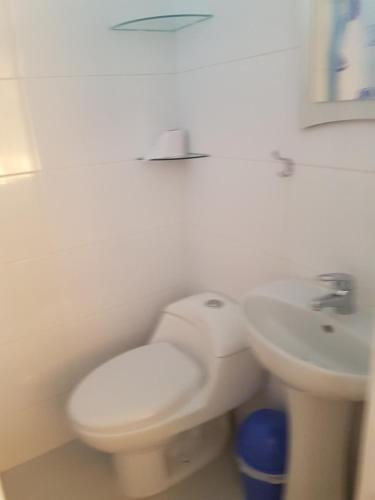 a white bathroom with a toilet and a sink at La Casa de Chamo in Arequipa