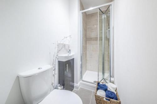 a white bathroom with a toilet and a shower at Kirkgate Apartments in Bradford