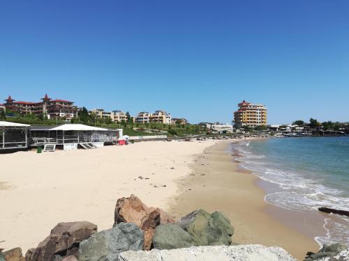 a beach with rocks and the ocean and buildings at Hotel Diva in Ravda