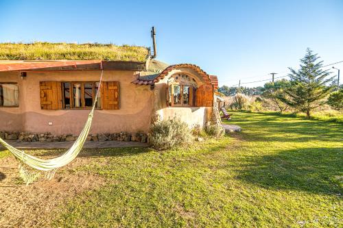 a house with a hammock in front of it at Alojamiento Ecológico Kurache in Tandil
