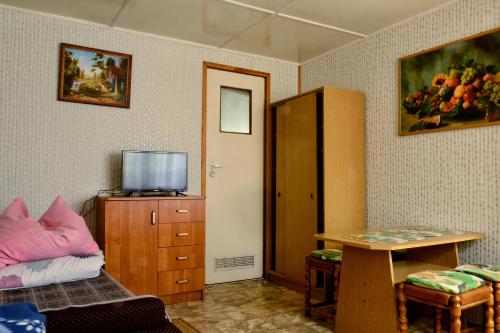 a room with a bed and a table and a cabinet at Domki letniskowe U GOSI in Trzęsacz
