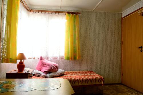 a bedroom with a bed with a pink pillow and a window at Domki letniskowe U GOSI in Trzęsacz