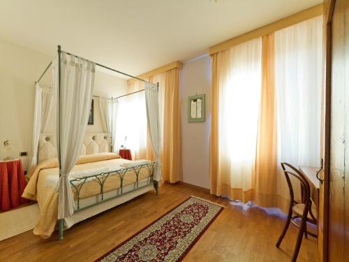 a bedroom with a canopy bed and a window at Villa Butussi - L'ospitalità del Vino in Corno di Rosazzo