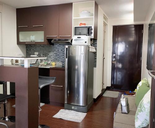 a kitchen with a refrigerator and a microwave at Solano Hills-1 bedroom unit in Manila