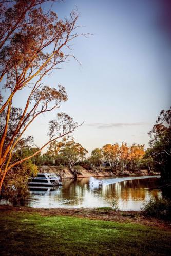 a river with a boat in the middle at Cadell On The Murray Motel in Moama