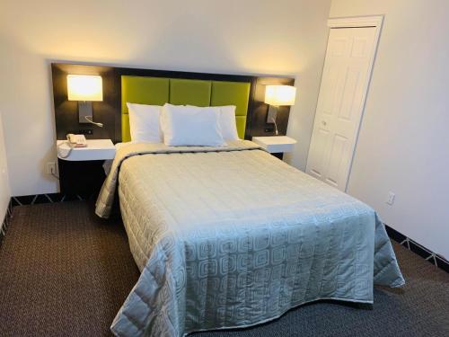 a bedroom with a large bed with two tables and two lamps at King Hotel in Palmerston