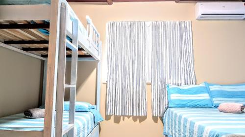 a bedroom with two bunk beds and a ladder at Linda Casa de Praia em Itacimirim in Itacimirim