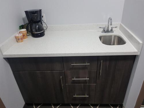 a kitchen counter with a sink and a coffee maker at King Hotel in Palmerston