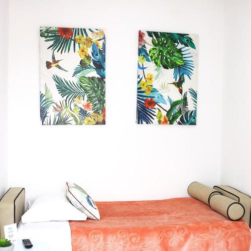 two paintings of tropical plants on a white wall at Avenida in Praia de Mira