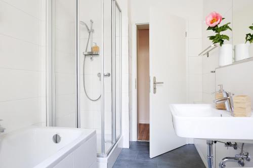 a white bathroom with a sink and a shower at Be in Berlin Apartments in Prenzlauer Berg in Berlin