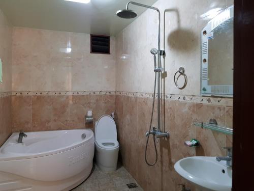 een badkamer met een bad, een toilet en een wastafel bij Khách sạn Anh Đào in Phủ Lý