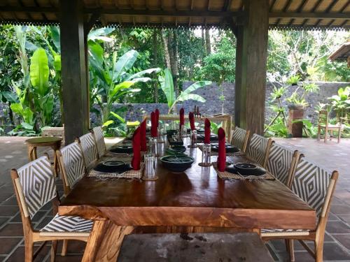 a wooden table with red napkins on top of it at Alas Arum Ecolodge in Tabanan
