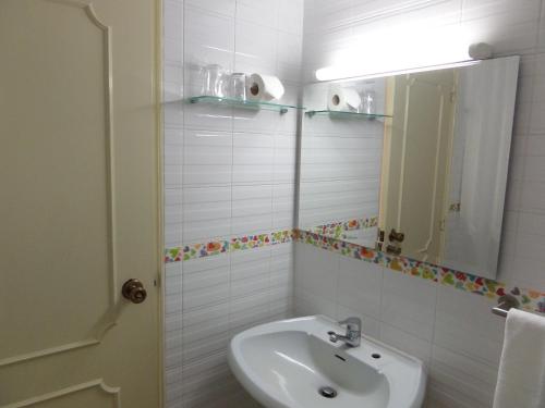 a white bathroom with a sink and a mirror at Mirachoro Albufeira in Albufeira