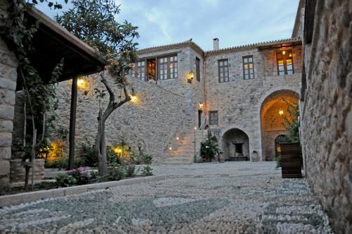 a stone building with a stone pathway in front of it at Archontiko Hatzipanayioti in Leonidion