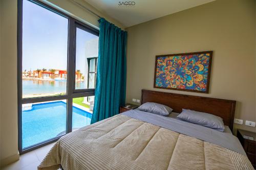 a bedroom with a bed and a large window at Tawila Island Tip Spacious 5 bedroom Villa in Gouna in Hurghada