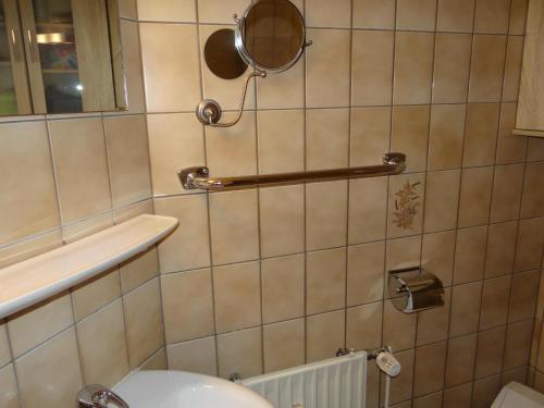 een badkamer met een toilet en een spiegel aan de muur bij 50097... in Carolinensiel