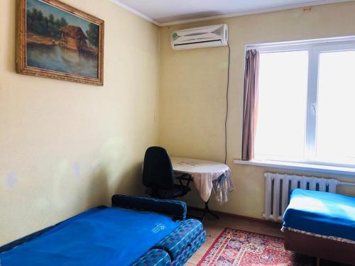 a room with a bed and a desk and a window at Mukarama-Apa in Bishkek