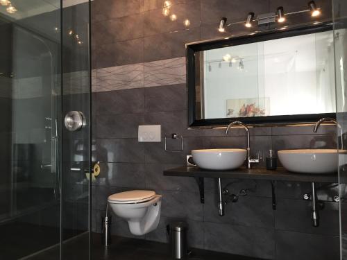 a bathroom with a toilet and two sinks and a shower at Apartments Nora & Lucija in Baška