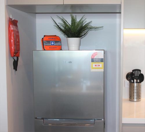 a refrigerator with a plant on top of it at Stunning Views Sydney Olympic Park in Sydney