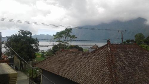 a roof of a house with a mountain in the background at The Villa's Kubu Sandan in Kintamani