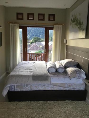 a bedroom with a bed with a large window at The Villa's Kubu Sandan in Kintamani