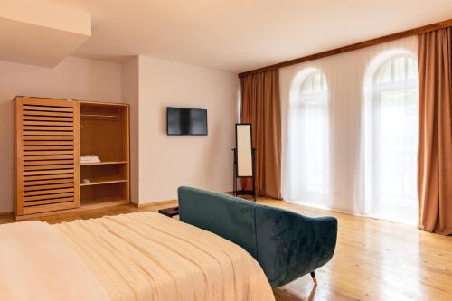 a bedroom with a couch and a tv in a room at Hotel Posta in Mestia