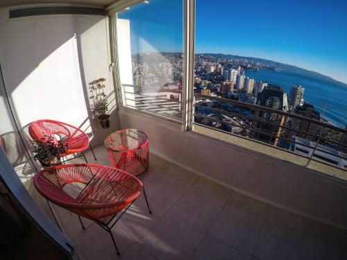 a balcony with red chairs and a view of the city at Departamentos Alto Libertad in Viña del Mar