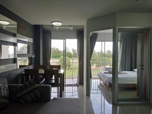a bedroom with a bed and a dining room with a balcony at Grandbeach2 B52 By malai in Mae Pim