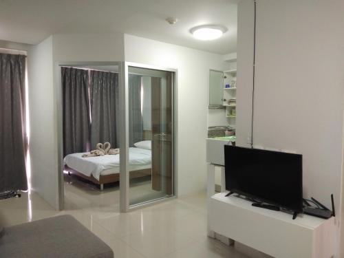 a living room with a television and a bedroom at Grandbeach2 B52 By malai in Mae Pim