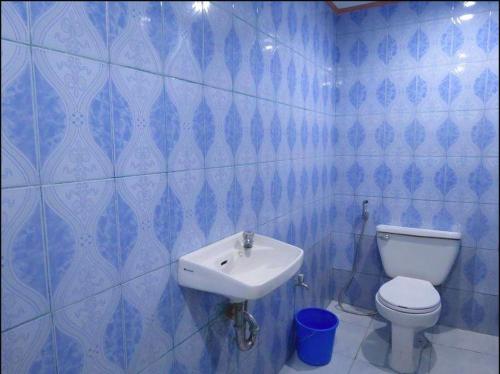 uma casa de banho em azulejos azuis com um WC e um lavatório em Anilao Scuba Dive Center (ASDC) em Batangas City