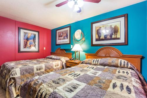 two beds in a room with red and blue walls at Rodeway Inn & Suites Big Water - Antelope Canyon in Big Water