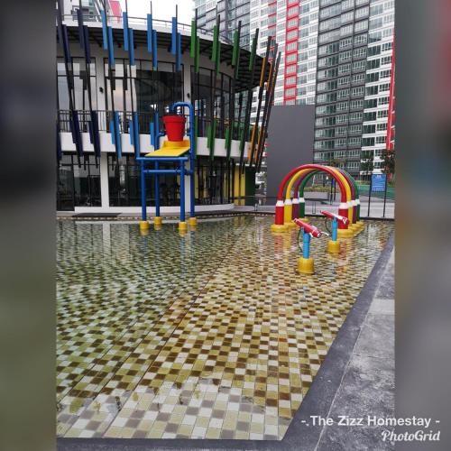 a pool of water with a playground in front of a building at The Zizz Homestay@Damansara Damai in Petaling Jaya