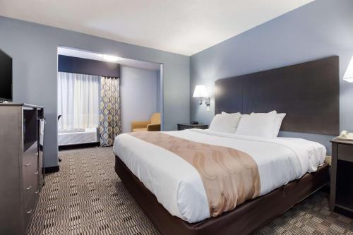a hotel room with a large bed and a television at Quality Inn & Suites in McCook