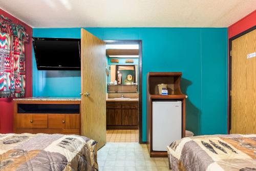 a room with two beds and a bathroom with a sink at Rodeway Inn & Suites Big Water - Antelope Canyon in Big Water