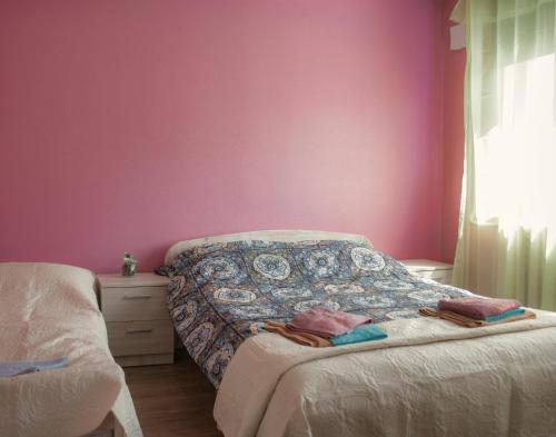a bedroom with pink walls and a bed and a window at Haava Apartment in Haapsalu