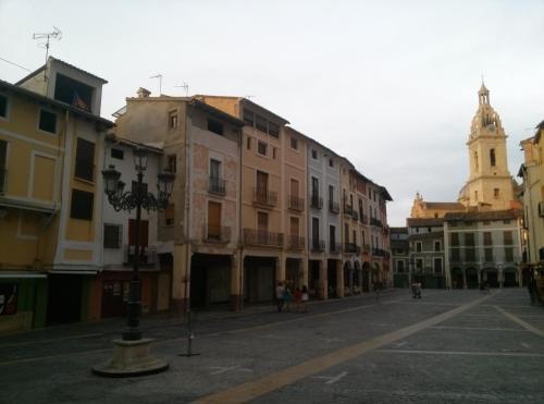 an empty city street with buildings and a clock tower at Las Coles Apartasuites in Xàtiva